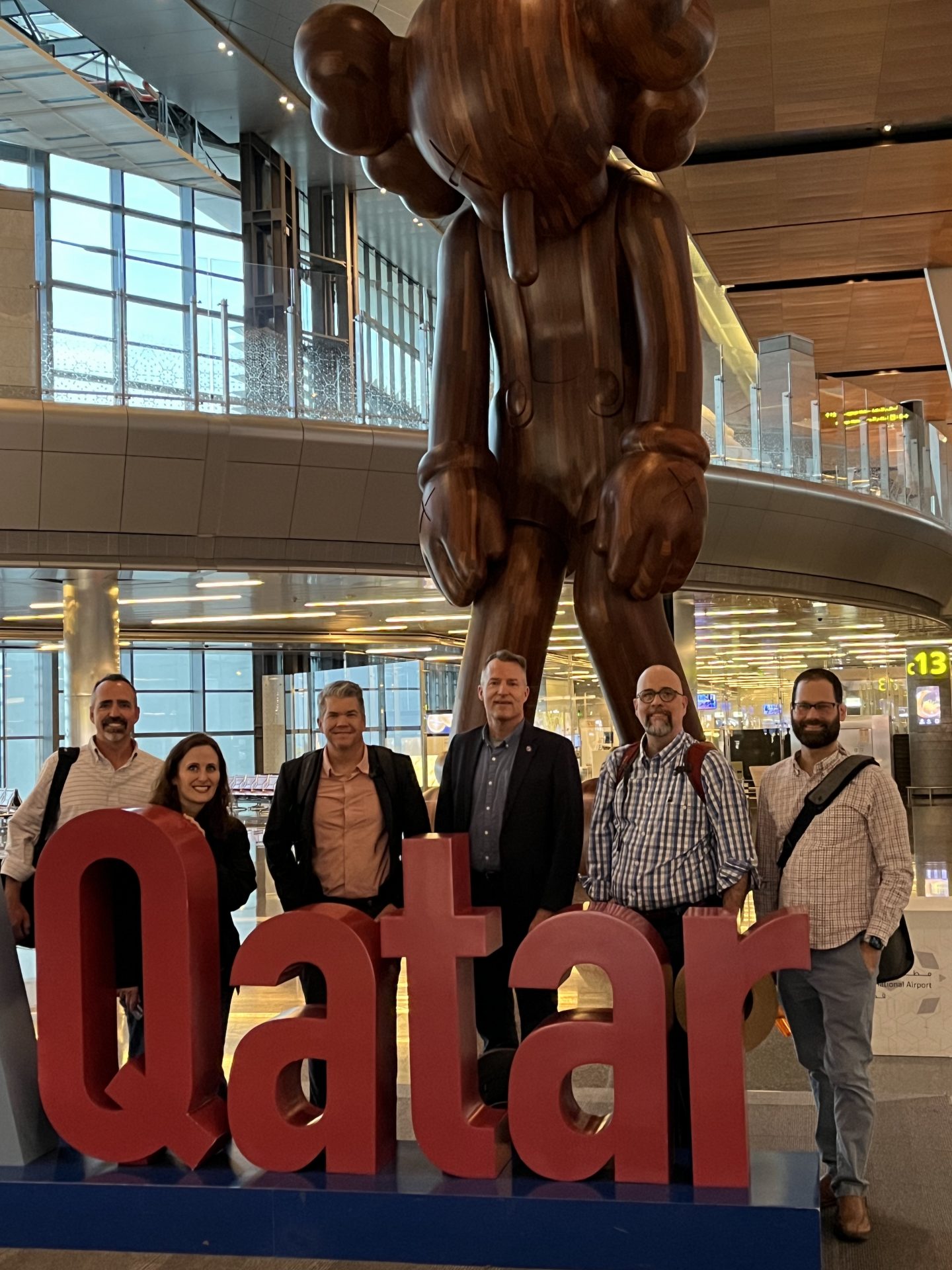 Mike McDonald, Jessica Jones, Alex Farmer, Chris McCarthy, Keith Allen, and Samuel Horowitz in the airport in Doha, Qatar.